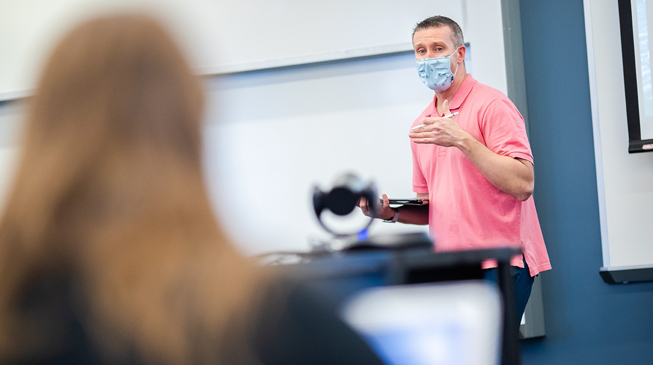 Professor Sean Coary teaching in Schreiber wearing a mask